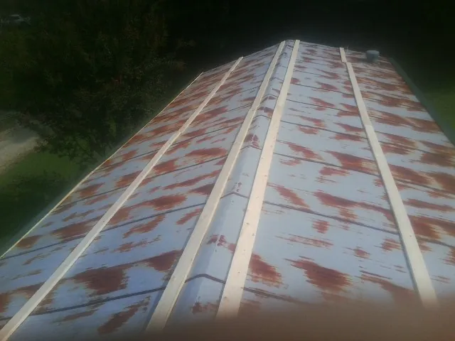 Rusted metal roof panels with new wood purlins before replacement — Storm Damage Roof Repair in Stover by Roofing Brothers