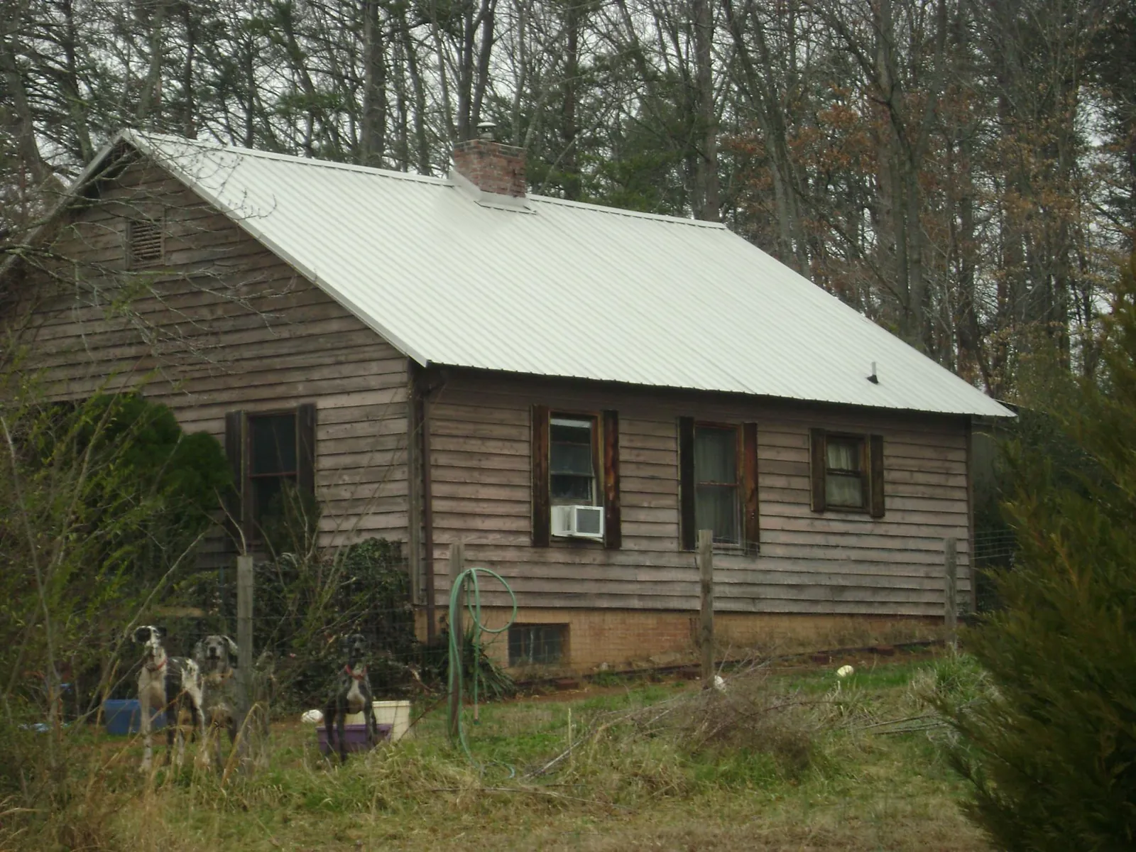 White metal roof on an old wood sided farmhouse, from a Metal Roof Installation job in Stover